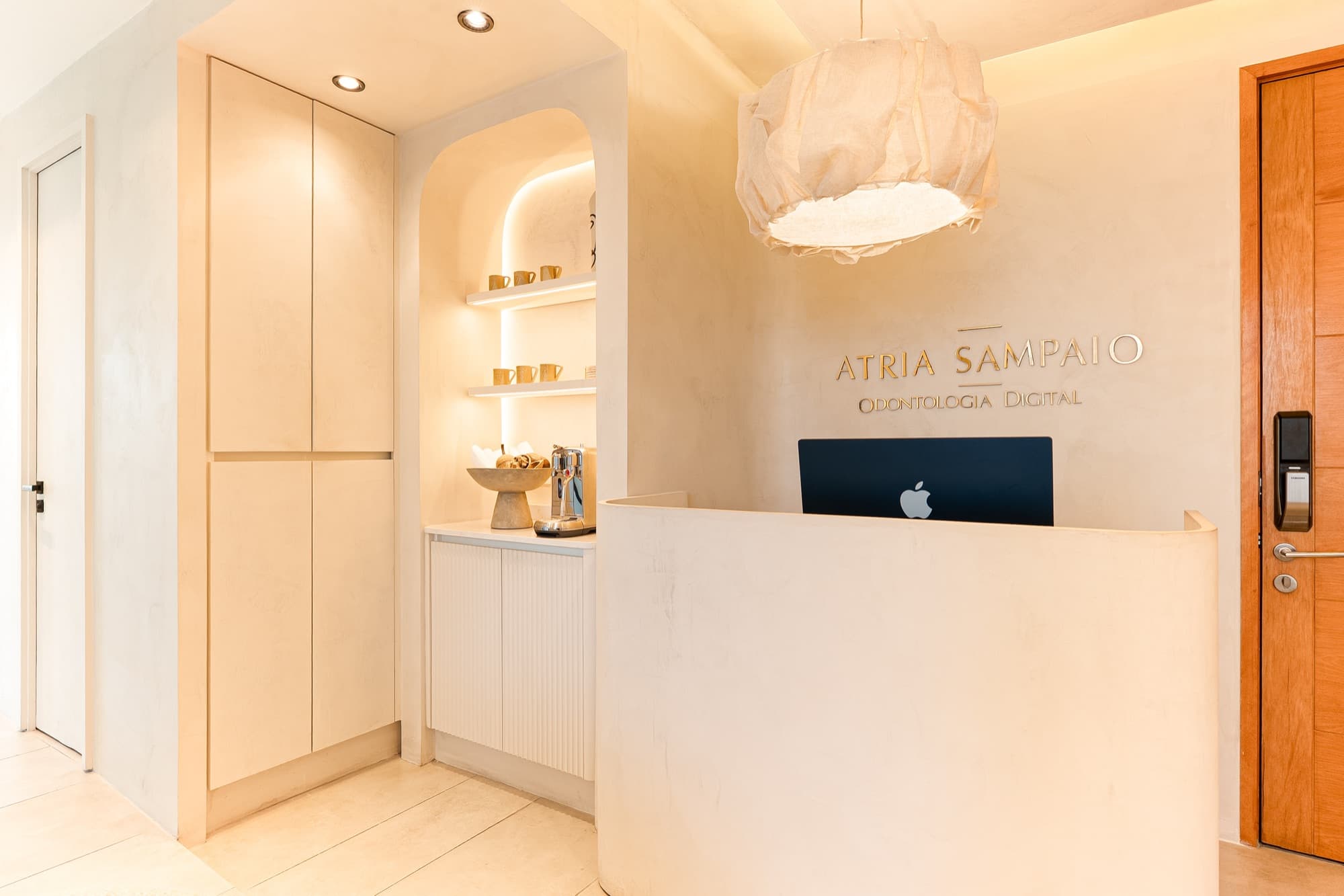 AS Odontología Digital reception with backlit niche and pendant lamp